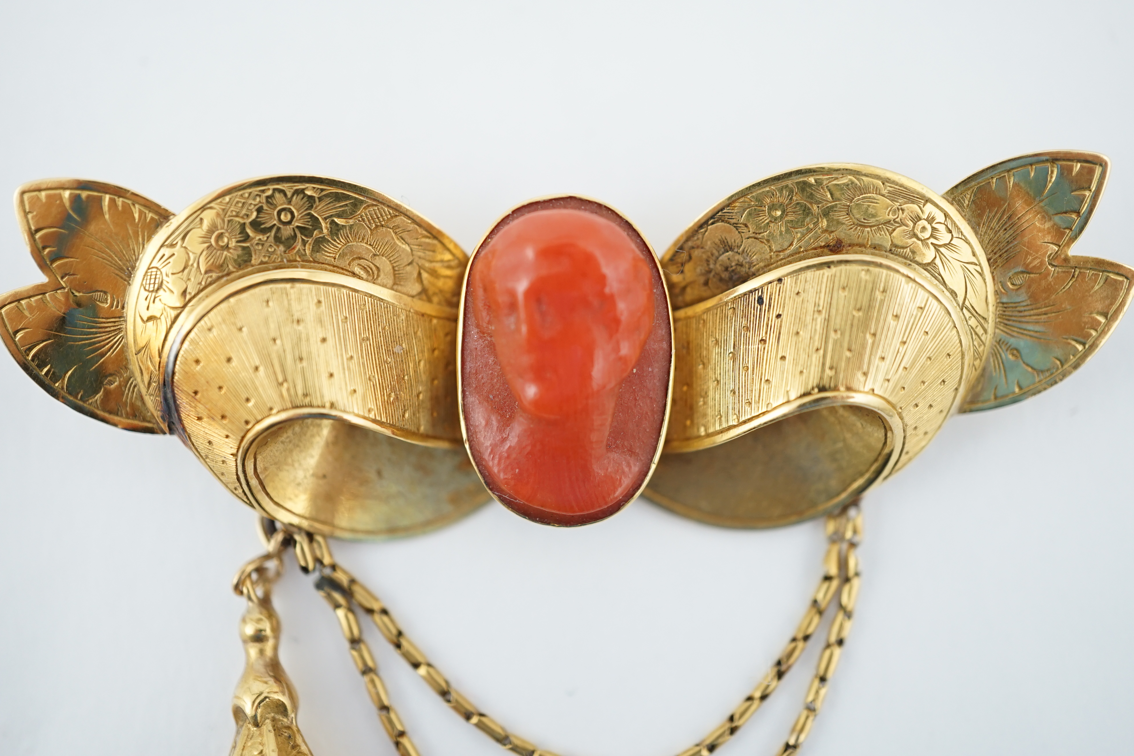 An early 20th century engraved gold and coral set drop brooch